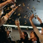 People enjoying a lively New Year's Eve party with champagne and confetti indoors.