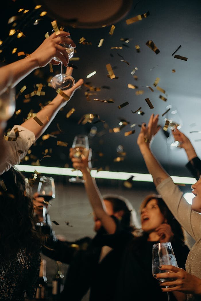 People enjoying a lively New Year's Eve party with champagne and confetti indoors.